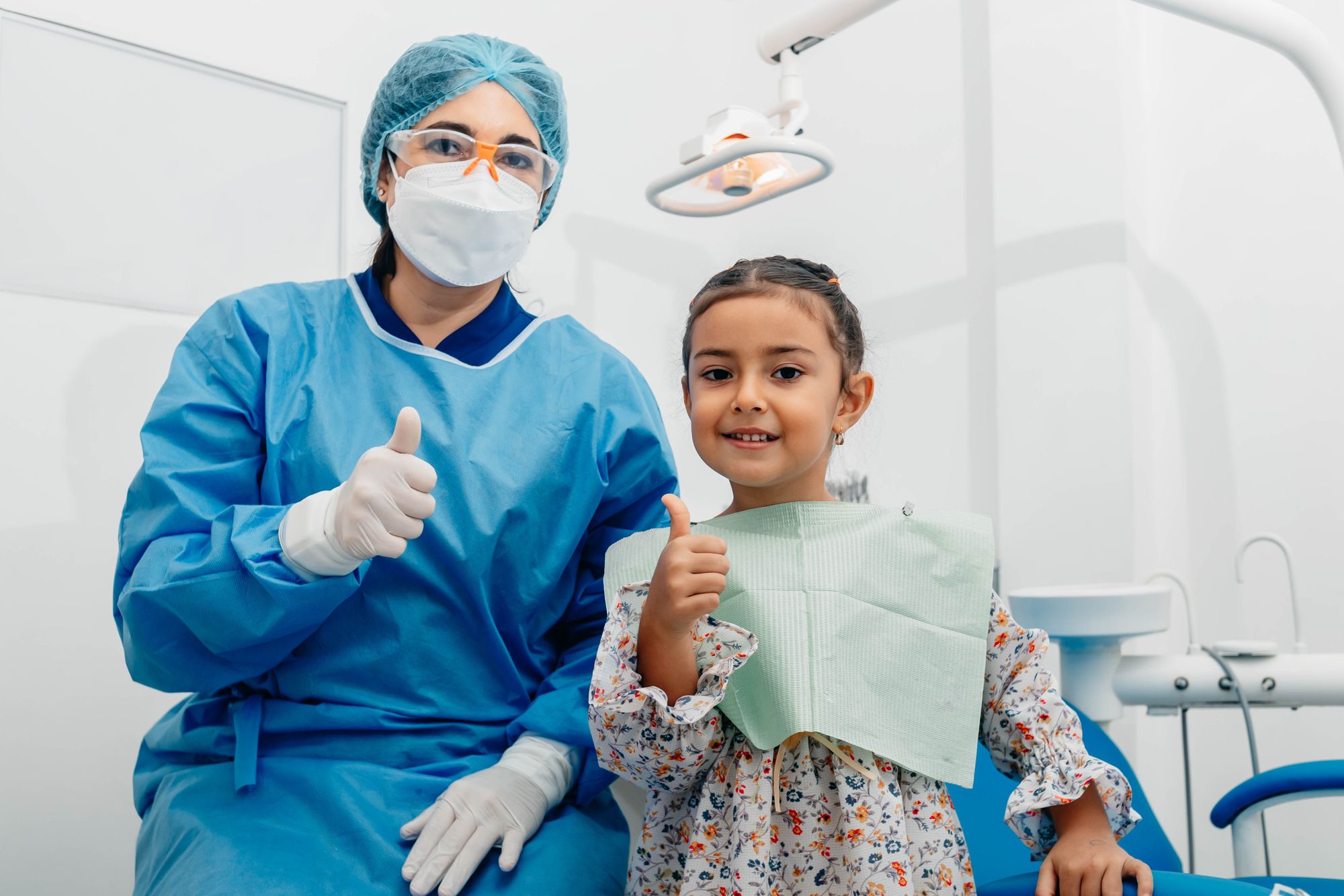 A dentist and a young patient smiling together in the treatment room